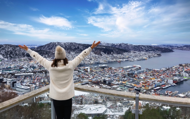Touristin genießt die Winterlandschaft mit Blick auf das Stadtbild von Bergen in Norwegen